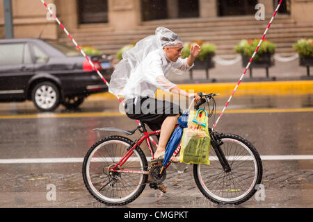 Un cycliste tente de faire des progrès au cours des vents en rafales comme Typhon Haikui a atteint les côtes de l'est de la Chine d'effectuer vie de 23 millions de personnes dans le centre des affaires de Shanghai le 8 août 2012 à Shanghai, Chine. Banque D'Images