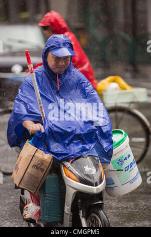 Un cycliste moteur essaie de faire des progrès au cours des vents en rafales comme Typhon Haikui a atteint les côtes de l'est de la Chine d'effectuer vie de 23 millions de personnes dans le centre des affaires de Shanghai le 8 août 2012 à Shanghai, Chine. Banque D'Images