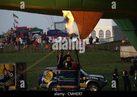 11 août 2012, 34e Bristol International Balloon Fiesta, Bristol, Royaume-Uni. Les brûleurs sont allumés pour remplir le couvert et lancer le ballon à air chaud. Banque D'Images