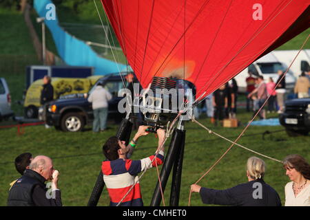 11 août 2012, 34e Bristol International Balloon Fiesta, Bristol, Royaume-Uni. Aérostiers enflammer les brûleurs pour gonfler le ballon. Banque D'Images