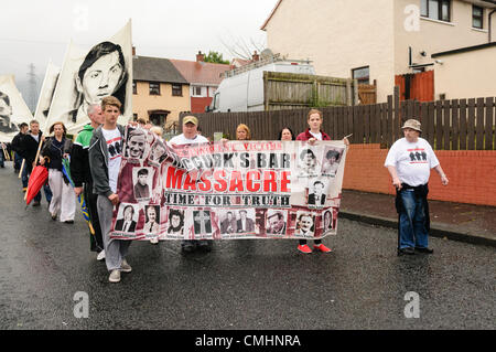 12 août 2012. Belfast. Les gens portent une bannière commémorant les morts causées lorsqu'une bombe a été placée à l'intérieur de McGurk's bar en 1971 Banque D'Images