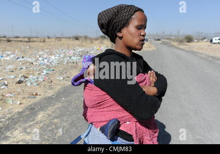 17Th Aug 2012. RUSTENBURG, AFRIQUE DU SUD : Nobatho Ongezwe Skhuze avec sa fille sur les lieux de la fusillade qui a eu lieu en dehors de l'établissement informel Nkaneng près de la mine de Lonmin le 17 août 2012 dans le nord-ouest, Afrique du Sud. Le mari d'Skhuze a disparu depuis le tournage. Il a été confirmé que 34 mineurs en grève ont été tués, et 78 blessés. (Photo par Gallo Images / Photos / Felix24 Dlangamandla). Credit : Gallo images / Alamy Live News Banque D'Images