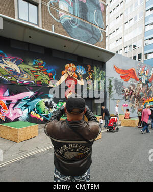 Bristol, Royaume-Uni. 18 août, 2012. Un homme prend une photo d'une partie des œuvres d'art peintes sur l'extérieur des bâtiments à Nelson Street dans le cadre du projet d'art ne voient pas. Bristol, UK,le samedi 18 août 2012,. Banque D'Images