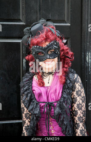 Femme. Fille portant un costume de goth violet avec masque pour les yeux Whitby, Yorkshire, 2013.Trinity Stark, portant une robe de fantaisie, un masque et une perruque rouge lors du plus grand week-end Goth & alternative du Royaume-Uni.Whitby.Goths, romantics et amateurs de macabre au Whitby Goth Weekend, qui est devenu leur maison spirituelle.En plus de Goths, il y a toutes sortes de personnages étranges et merveilleux avec des visages cachés à l'Halloween Special fondée par JO Hampshire en 1994. Banque D'Images