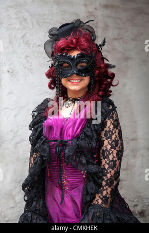 Femme. Fille portant un costume de goth violet avec masque pour les yeux Whitby, Yorkshire, 2013.Trinity Stark, portant une robe de fantaisie, un masque et une perruque rouge lors du plus grand week-end Goth & alternative du Royaume-Uni.Whitby.Goths, romantics et amateurs de macabre au Whitby Goth Weekend, qui est devenu leur maison spirituelle.En plus de Goths, il y a toutes sortes de personnages étranges et merveilleux avec des visages cachés à l'Halloween Special fondée par JO Hampshire en 1994. Banque D'Images