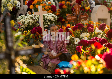 Une vieille femme mexicaine s'assied à la tombe d'un être cher à la riche décoration San Antonillo Castillo Velasco Cemetery pendant le jour de la Fête des Morts connus en espagnol comme d'un de muertos le 3 novembre 2013 à Ocotlan, Oaxaca, Mexique. Le cimetière a un concours du meilleur décorées tombe. Banque D'Images