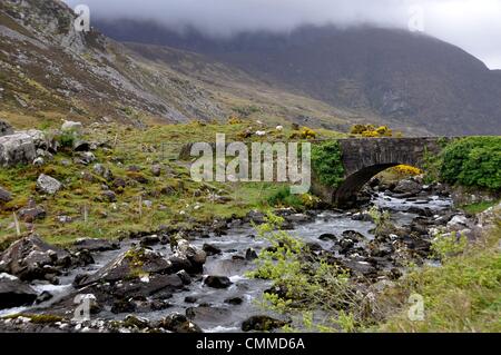 Eine alte Bogenbrücke überspannt den Fluss Loe im Gap of Dunloe, elf von langen kilomètre Schlucht zwischen den montagnes pourpres auf der einen und dem Macgillycuddy Reek Auf der anderen Seite, aufgenommen am 28. Mai 2013. Die Schlucht ist schon seit langem eine touristische Attraktion und das - bei jedem Wetter. Die Straße durch die Schlucht ist eng, kurvenreich und für größere Wagen eher nicht befahrbar. Foto : Frank Baumgart un vieux arch pont traverse la rivière Loe dans le Gap of Dunloe, un col de montagne à 11 kilomètres de long entre les Macgillycuddy Reek et les montagnes dans le comté de pourpre Banque D'Images