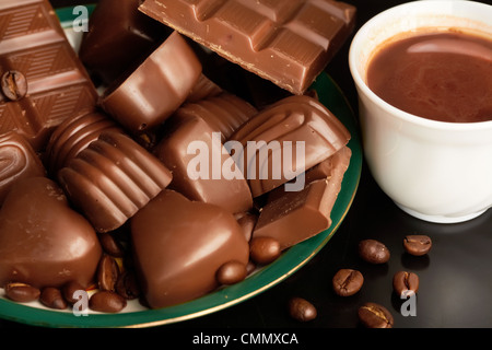 Close-up of cappuccino dans tasse de porcelaine, beaucoup de différents chocolats et les grains de café à proximité Banque D'Images