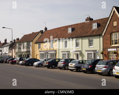 Le stationnement sur rue ; voitures garées sur le côté de la route dans le Hall Street, Long Melford, Suffolk, Angleterre. Banque D'Images