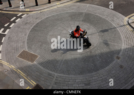 Vue aérienne de scooter bike rider comme il traverse les cercles d'une ville de Londres rond-point. Banque D'Images