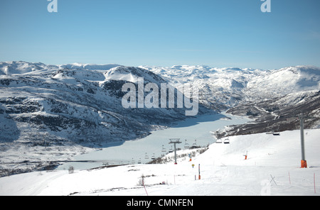 Regardant vers le bas des pistes de ski de montagne ; descente au village de Hovden et Breivevatnet dans Aust-Agder, Norvège du sud Banque D'Images