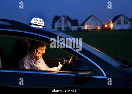 Jeune médecin, un médecin de campagne, généralistes dans le pays, après une soirée visite à domicile avec un malade, dans une voiture. Banque D'Images