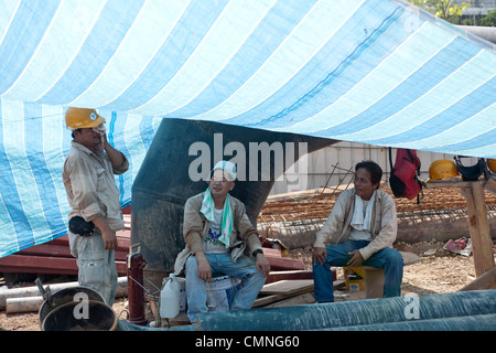 Les travailleurs migrants de la Chine prennent une pause sur le site de construction de Resorts World Sentosa de Singapour, le 25 juin 2009. Banque D'Images