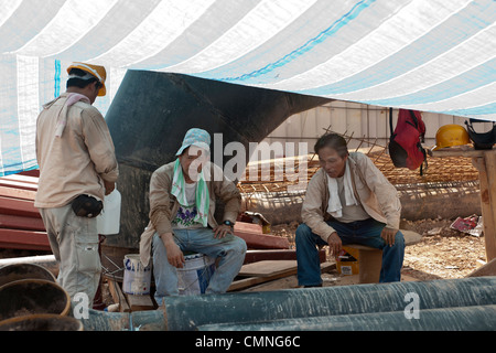 Les travailleurs migrants de la Chine prennent une pause sur le site de construction de Resorts World Sentosa de Singapour, le 25 juin 2009. Banque D'Images