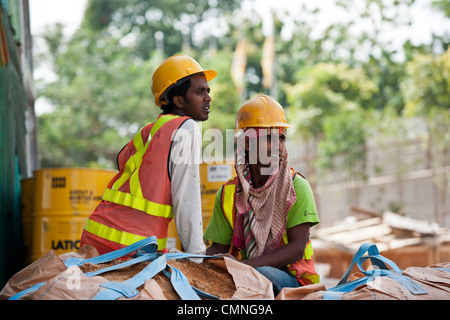 Les travailleurs migrants d'Asie du Sud prennent une pause sur le site de construction de Resorts World Sentosa de Singapour, le 25 juin 2009. Banque D'Images