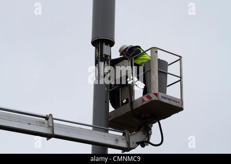 Mât de téléphonie mobile en cours de travail par deux hommes Banque D'Images