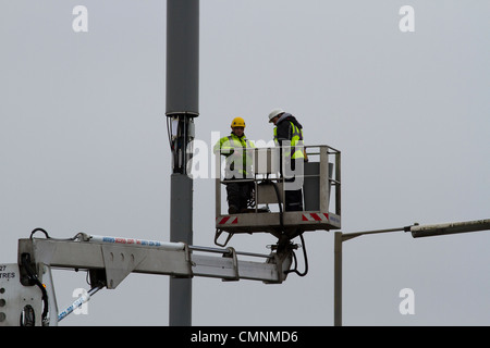 Mât de téléphonie mobile en cours de travail par deux hommes Banque D'Images