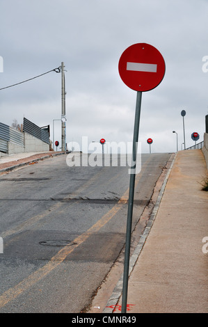 Pas d'entrée panneaux rouges sur la rue côté pente menant à la jonction de l'autoroute. Banque D'Images