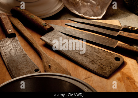 Couteaux anciens butcher cleaver sur une planche à découper. Banque D'Images