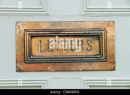 Un vieux meubles anciens en laiton ouvragé lettre mail box sur une porte avant de Lewes, East Sussex, Angleterre. Banque D'Images