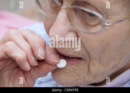 Femme âgée de prendre une aspirine - prises pour de nombreuses conditions de sauvetage Banque D'Images