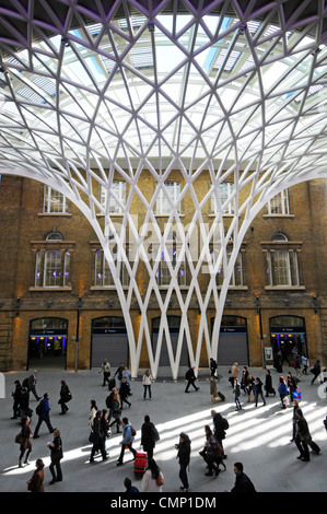 Départ de la gare de Kings Cross l'acier de construction concourse soutient la structure de toit futuriste à côté de la vieille gare murs de brique Londres Angleterre Royaume-Uni Banque D'Images