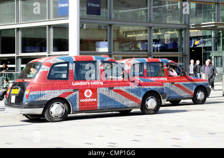 Paire noir taxi taxi temporairement couvert inhabituel Vodafone Londres appeler Drapeau Union Jack et texte tag mot nuage graphique publicitaire St Pancras Angleterre Royaume-Uni Banque D'Images