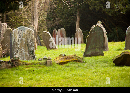 Les pierres tombales se penchant à différents angles, causant l'affaissement des tombes à tomber. Banque D'Images