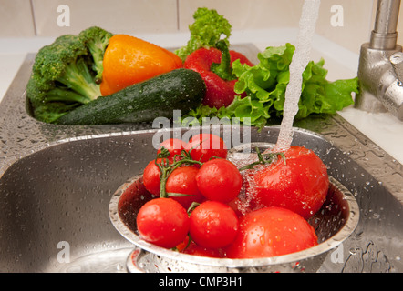 Des légumes frais aux éclaboussures dans l'eau avant la cuisson Banque D'Images