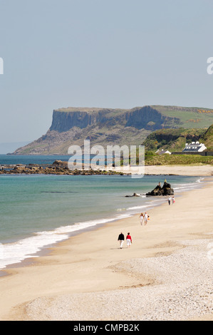 Jeune couple walking on Ballycastle Beach, dans le comté d'Antrim, en Irlande du Nord. En regardant vers la pointe de Fair Head Banque D'Images