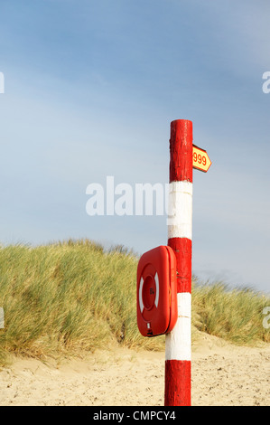 Les services d'urgence 999 téléphone indicatif d'appel. Bouée de sauvetage côtier life preserver post sur la plage. UK Banque D'Images