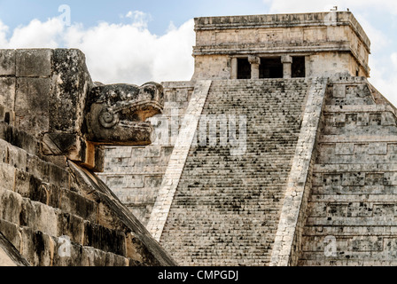 El Castillo Chichen Itza Tête de serpent gros plan | CHICHEN ITZA, Mexique — Une tête de serpent sculptée sur la plateforme Vénus encadre l'escalier nord d'El Castillo, l'axe le long duquel se déploie l'affichage d'ombre équinoxial célèbre de la pyramide chaque printemps et automne. Chacune des quatre escaliers compte 91 marches, totalisant 365 avec la plateforme sommitale — une pour chaque jour de l'année solaire maya — encodant le calendrier directement dans l'architecture de la pyramide. Banque D'Images