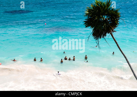 Plage des ruines mayas de Tulum Mexique // TULUM, Mexique — la plage de Tulum s'étend le long de la côte caribéenne sous les anciennes ruines mayas de Tulum, l'un des sites archéologiques précolombiens les mieux préservés du Mexique. Les ruines de Tulum, perchées sur des falaises de 12 mètres (39 pieds) surplombant les eaux turquoises, ont servi de port de commerce majeur pour la civilisation maya d'environ 1200 à 1450 EC. Cette ville fortifiée a été parmi les dernières colonies mayas à être habitées lorsque les conquistadors espagnols sont arrivés au début du XVIe siècle. Le site combine des plages de sable blanc avec des temples calcaires et des structures Banque D'Images