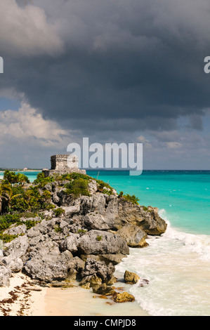 El Castillo, partie de la ruines mayas de Tulum, se trouve sur un éperon rocheux, au dos gris, des nuages menaçants dans la distance. Tulum était un port de commerce que nombreux échanges tout au long de l'Amérique centrale et le centre du Mexique. Il est maintenant une destination touristique populaire, en partie parce qu'il est assis sur de belles plages des Caraïbes. Banque D'Images