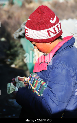 Jeune garçon à compter de l'argent dans le nord du Sichuan, Chine Banque D'Images