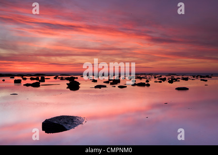 Des rochers et de réflexions dans la mer au lever du soleil, Saltwick Bay, Yorkshire, Angleterre, Royaume-Uni, Europe Banque D'Images