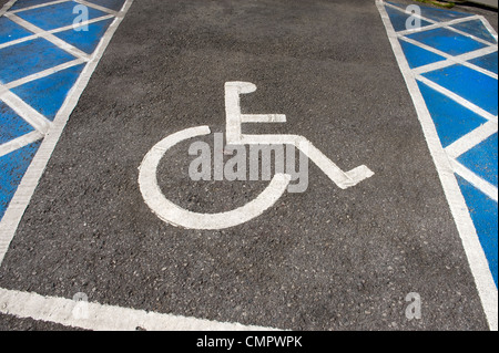 Une baie de stationnement pour personnes handicapées en fauteuil roulant avec des chevrons au parking et signe Banque D'Images