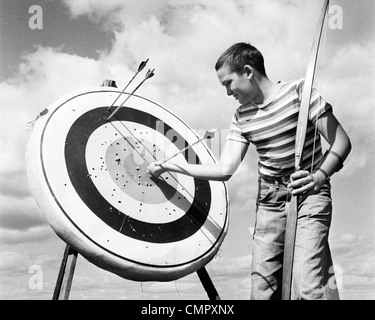 1960 JEANS GARÇON T-shirt à rayures HOLDING BOW & ARROW TIRANT HORS DE CIBLER L'oeil de boeuf Banque D'Images