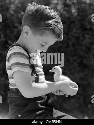 1950 BOY SMILING BABY DUCK EN PLEIN AIR D'ÉTÉ Banque D'Images