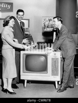 Années 1950 Années 1960 COUPLE QUI ACHÈTE UNE NOUVELLE CONSOLE DE L'APPAREIL DE TÉLÉVISION VENDEUR Banque D'Images