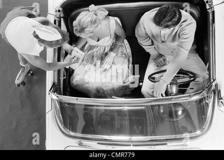 Années 1950 Années 1960 VUE AÉRIENNE DU CARHOP SUR PATINS À PRENDRE COMMANDE DE COUPLE AUTOMOBILE Banque D'Images