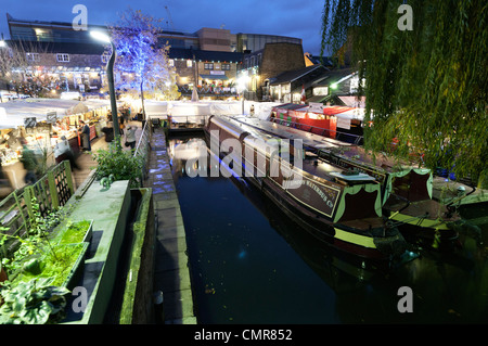 Bateaux amarrés dans le canal étroit du bassin, Camden Lock Market, Londres la nuit. Banque D'Images