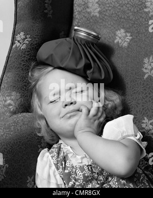 1940 JEUNE FILLE AVEC POCHE DE GLACE SUR LA TÊTE DE DORMIR Banque D'Images