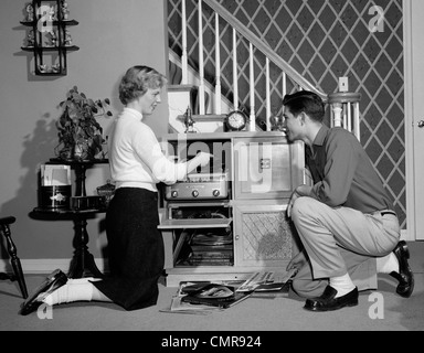 1950 TEENAGE COUPLE PLAYING HI-FI RECORDS Le phonographe CONSOLE DANS LA SALLE DE SÉJOUR Banque D'Images