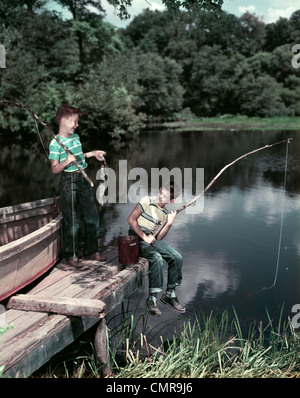 Années 50, deux garçons DANS LE LAC DE PÊCHE DE LA STATION D'OUTDOOR Banque D'Images