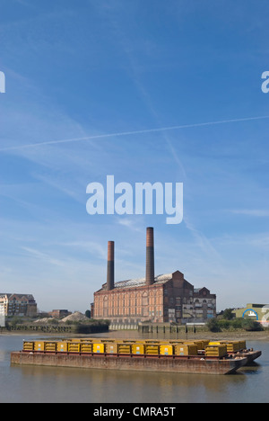 L'ancien lots road power station, vu de l'autre côté de la Tamise à Battersea, avec un chaland de charge en premier plan Banque D'Images