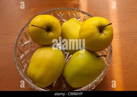 Pommes Golden Delicious dans crystal bol de fruits nature morte. Banque D'Images