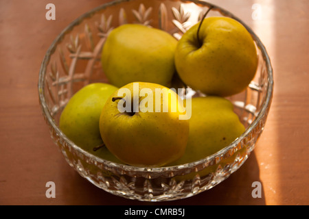 Pommes Golden Delicious dans crystal bol de fruits nature morte. Banque D'Images