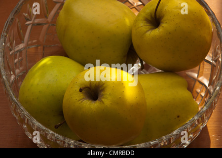 Pommes Golden Delicious dans crystal bol de fruits nature morte. Banque D'Images