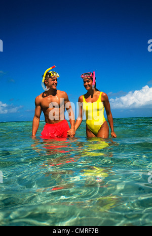 Années 90, couple avec masques et tuba, DEBOUT DANS L'EAU PROFONDE DE LA CUISSE Tobago Cays, West Indies Banque D'Images